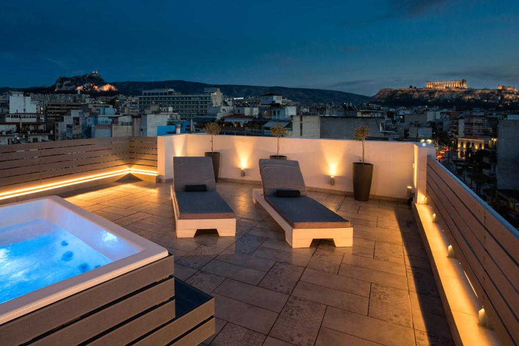 a rooftop patio with a hot tub and two benches at The Loft Athens in Athens