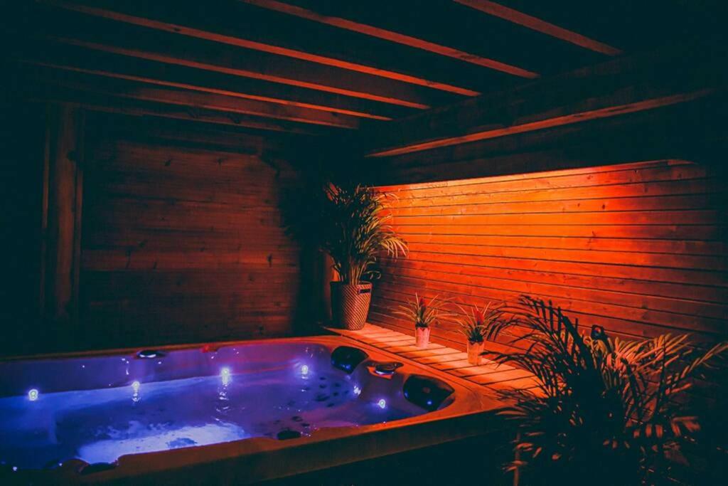 baño con bañera con plantas. en Le Spa du Cabanon: Cabanon de luxe avec Spa entièrement privatif, en Aye