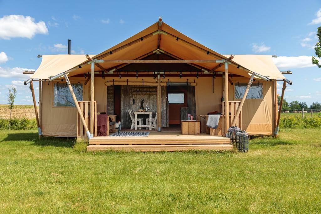 a large tent with a porch in a field at Frei wie der Wind-Glamping in Dierhagen