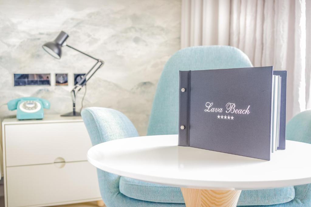 a white table with blue chairs and a book on it at Hotel Lava Beach in Puerto del Carmen