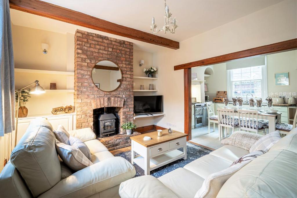 sala de estar con sofá y chimenea en The Cottage in Chester, Sleeps 6 with FREE Parking en Chester