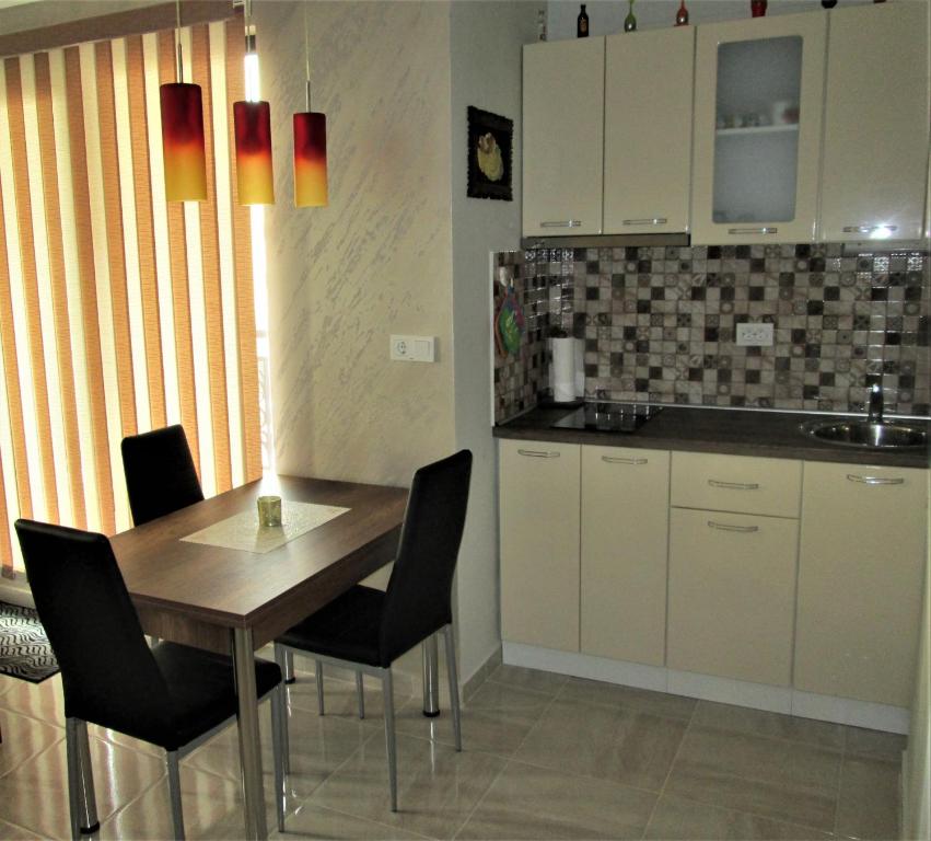 a kitchen with a wooden table and black chairs at Studio Emi in Pomorie