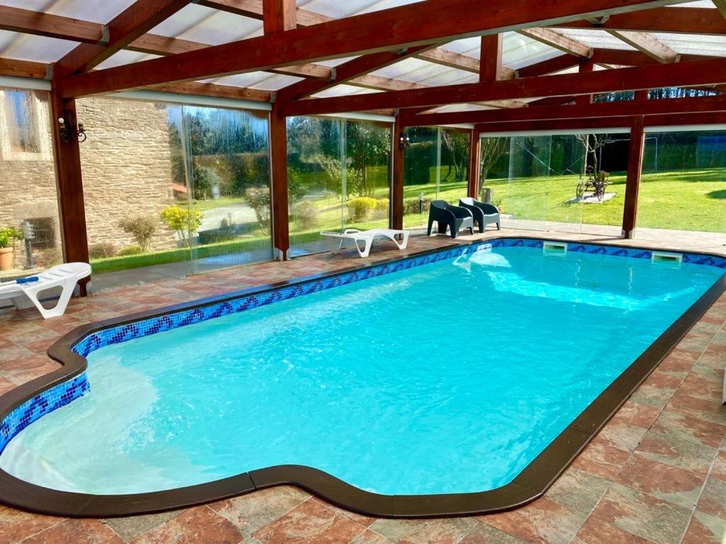 una piscina a sfioro con pergolato e piscina di Casa Compostela a Bama
