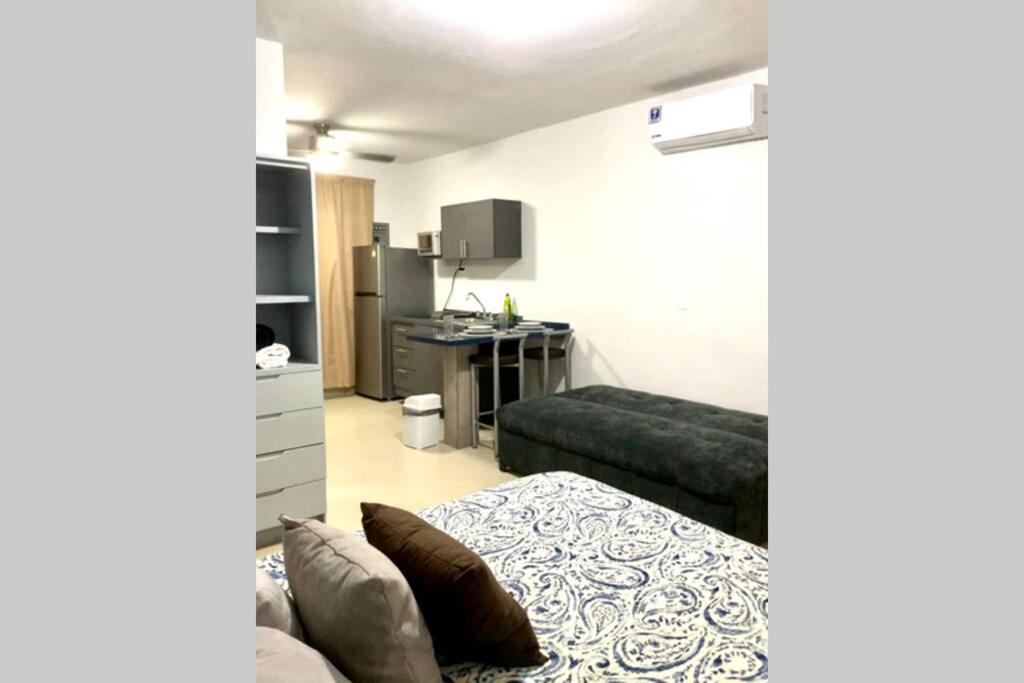- un salon avec un lit et un bureau dans l'établissement Increíble departamento privado, à Monterrey