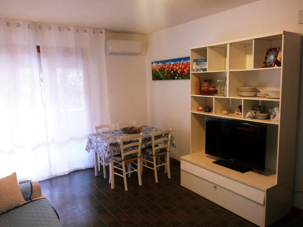 a living room with a dining room table and a television at Caletta Beach in Castiglioncello
