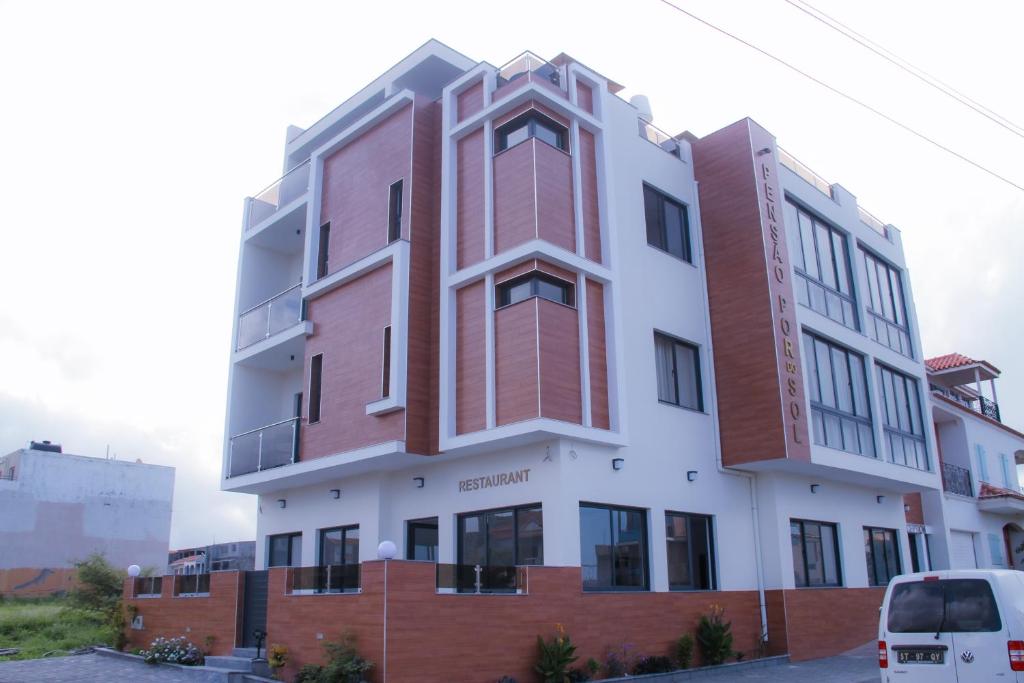 een hoog gebouw met een rood en wit bij Hotel Por Do Sol in Tarrafal
