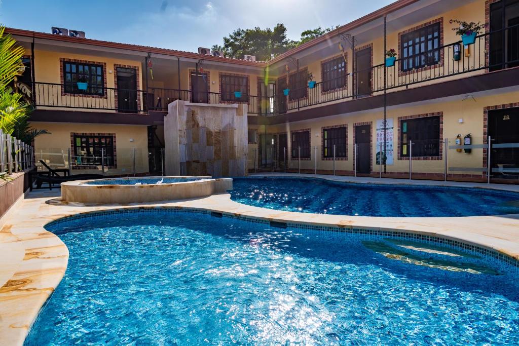 a swimming pool in front of a building at Hotel Vanguardia Natural in Villavicencio