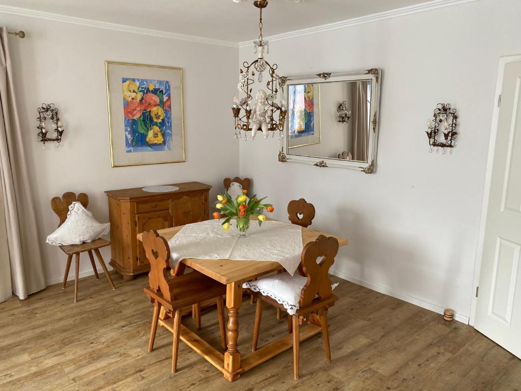 uma sala de jantar com uma mesa, cadeiras e um espelho em Ferienwohnung Giacomelli 1 em Rottach-Egern