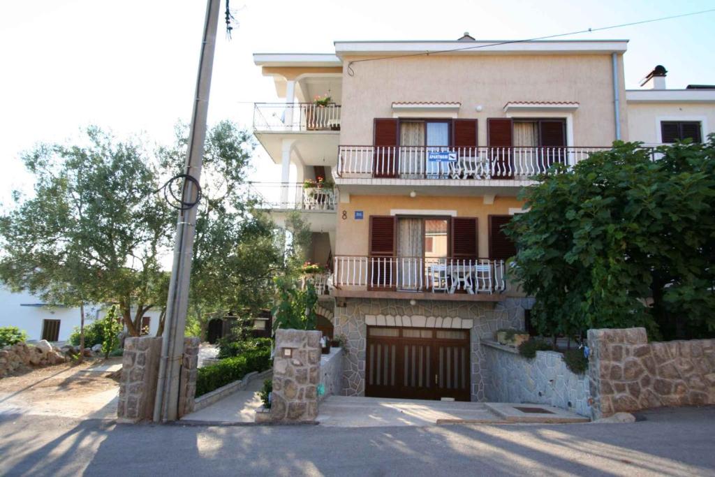 ein großes Haus mit einem Tor und einem Balkon in der Unterkunft One-Bedroom Apartment Silo near Sea 1 in Šilo