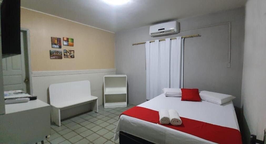 um quarto com uma cama com uma almofada vermelha em Hotel Pousada Mar Azul em Tamandaré