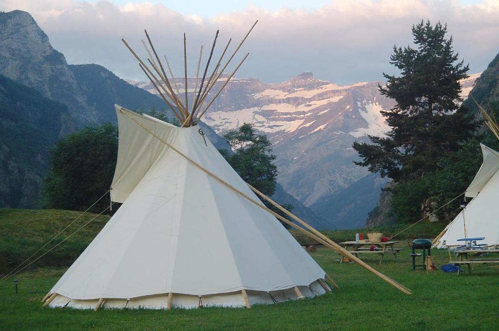 a white teepee tent with mountains in the background at Tipi nature grand confort in Gavarnie