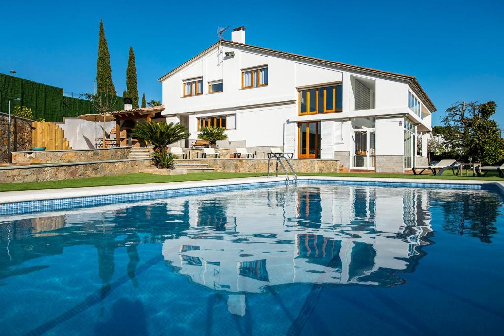 una casa y una piscina frente a una casa en Casa Mirestany- Wonderful house with amazing views, en Banyoles