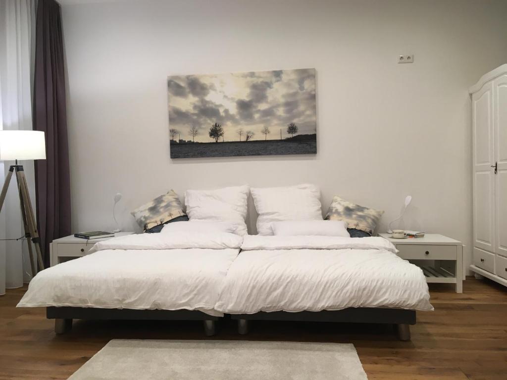 ゾーリンゲンにあるCity-Apartment Ohligsのベッドルーム1室(ベッド2台付)が備わります。壁には絵画が飾られています。