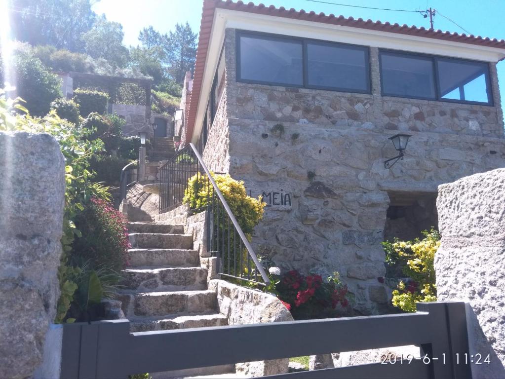 une maison en pierre avec des escaliers en face de celle-ci dans l'établissement Casa Colmeia, à Esposende