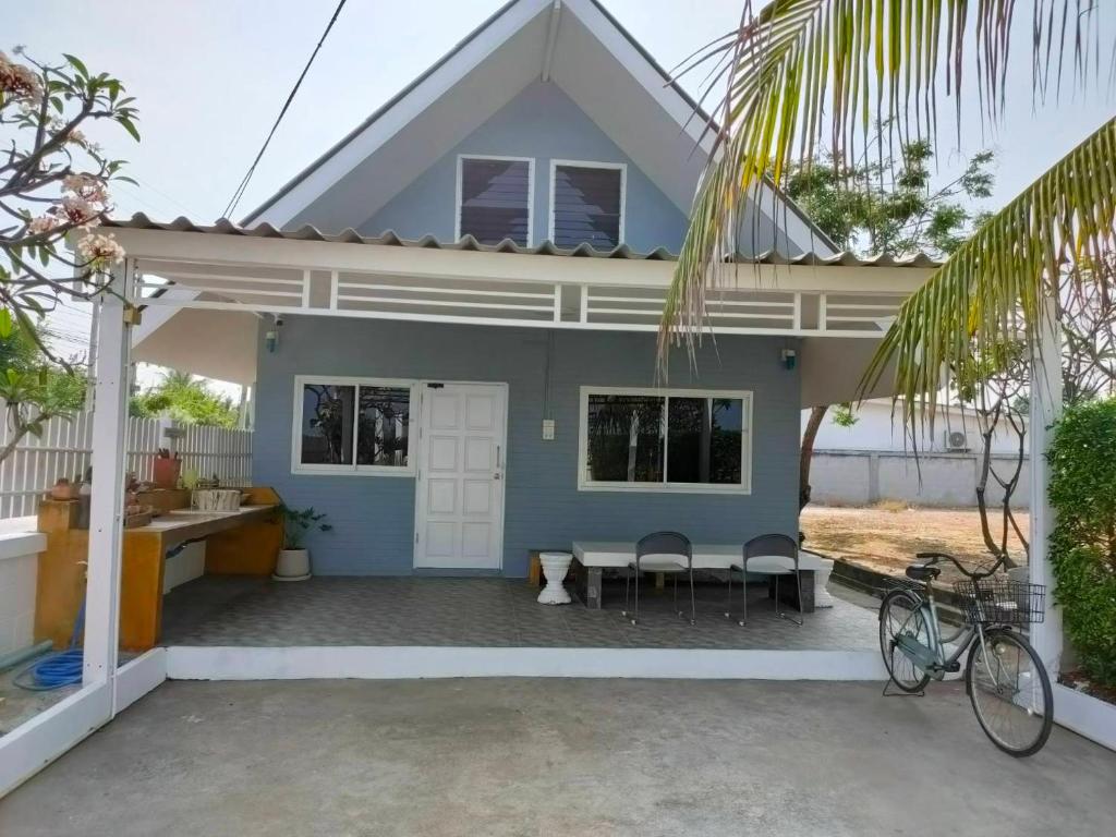 a blue house with a table and chairs at Pran sea & sun 2 in Pran Buri