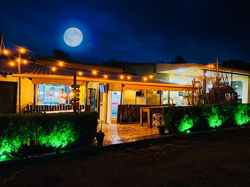 una casa illuminata di notte con la luna piena di Hostel Ilha do Amor a Fernando de Noronha