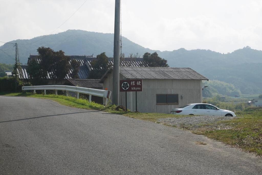 a white car parked on the side of a road at 民泊 桔梗 in Awaji