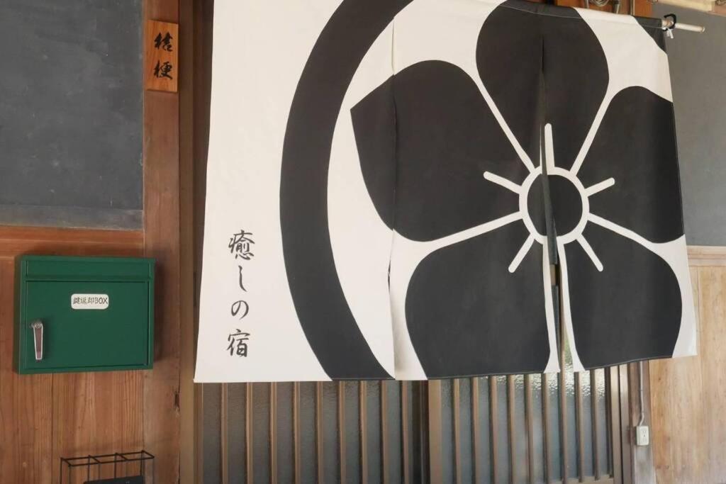 a wall with a painting of a cow on it at 民泊 桔梗 in Awaji