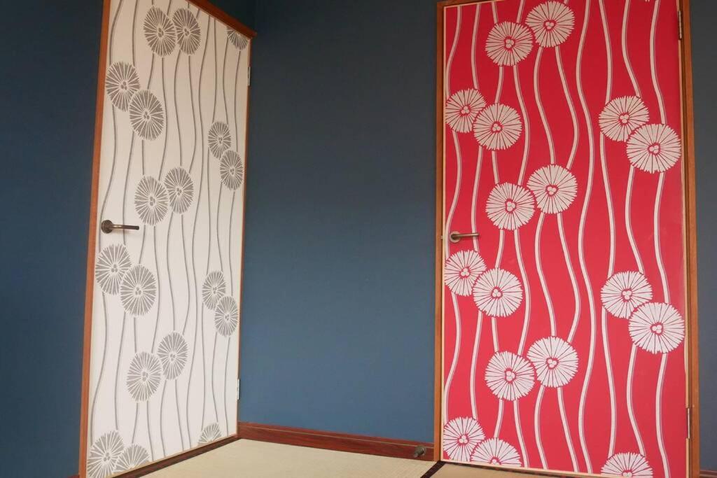 an open door with a red and white wall at 民泊 桔梗 in Awaji