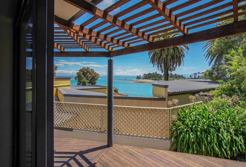 a view from a house balcony with a pergola at On The Rocks in Nelson