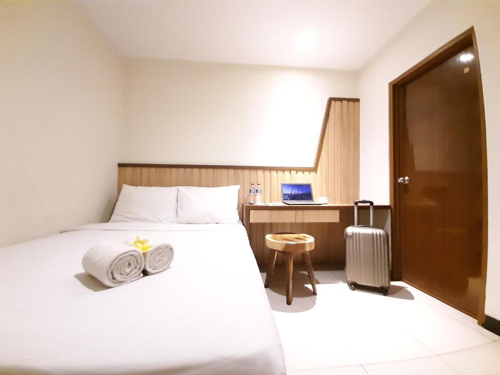 a hotel room with a bed with two towels on it at Hotel Pantes Kota Lama Semarang in Semarang