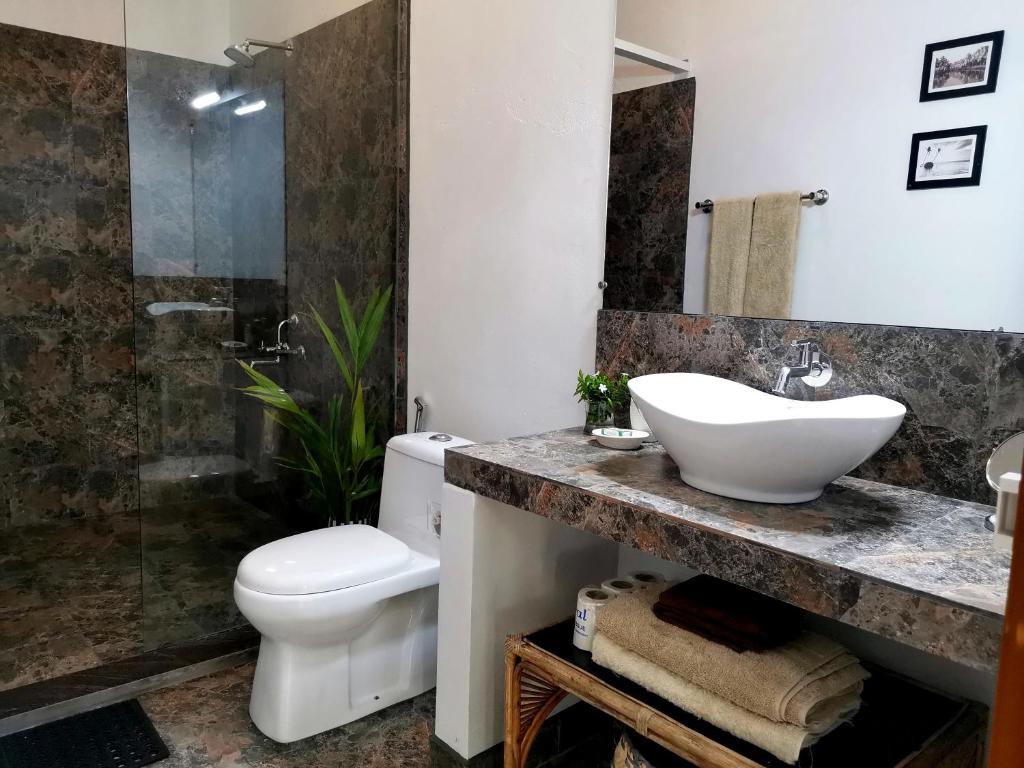 a bathroom with a sink and a toilet and a shower at Satta Beach Residence in Varkala