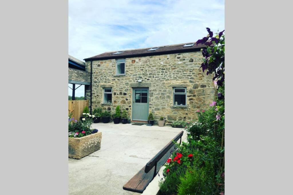 a stone house with a bench in front of it at Sheilas Cottage Sleeps 2 One dog allowed with prior permission in Barnard Castle