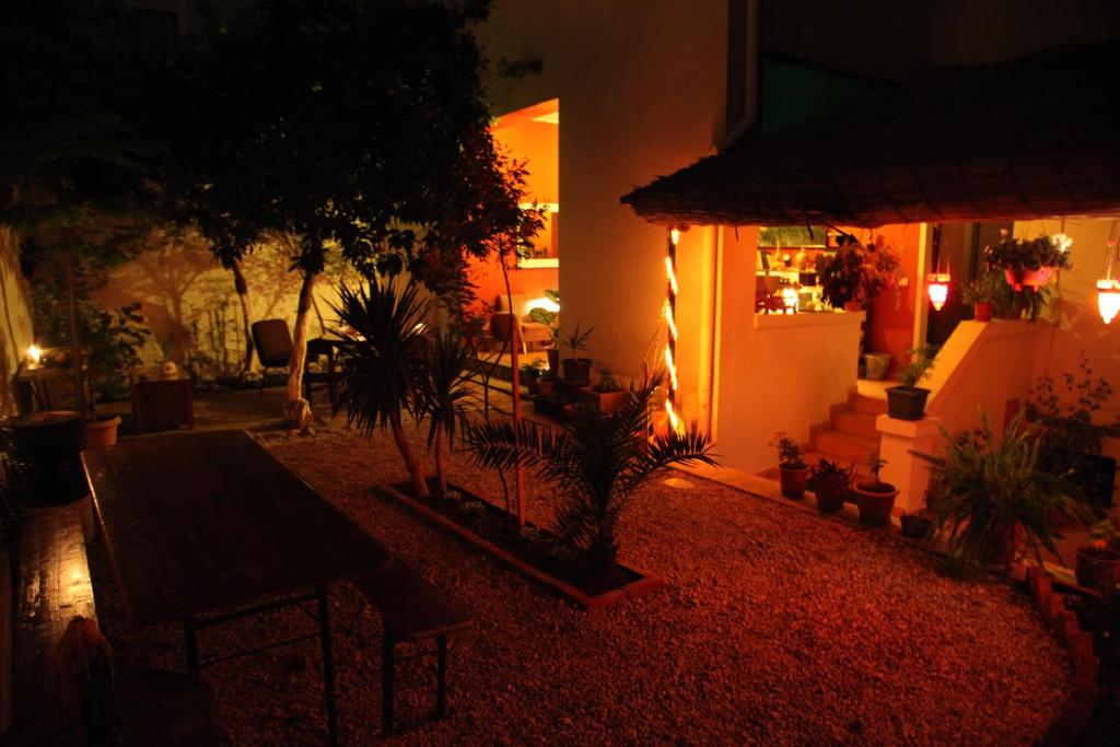 a patio at night with a table and plants at Trip'n'Hostel in Tirana