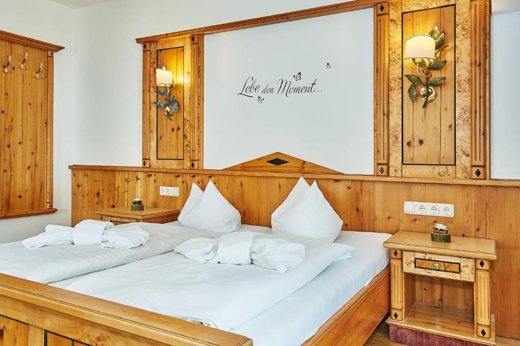 two beds with white pillows in a room at Klosterwirt Höglwörth in Anger