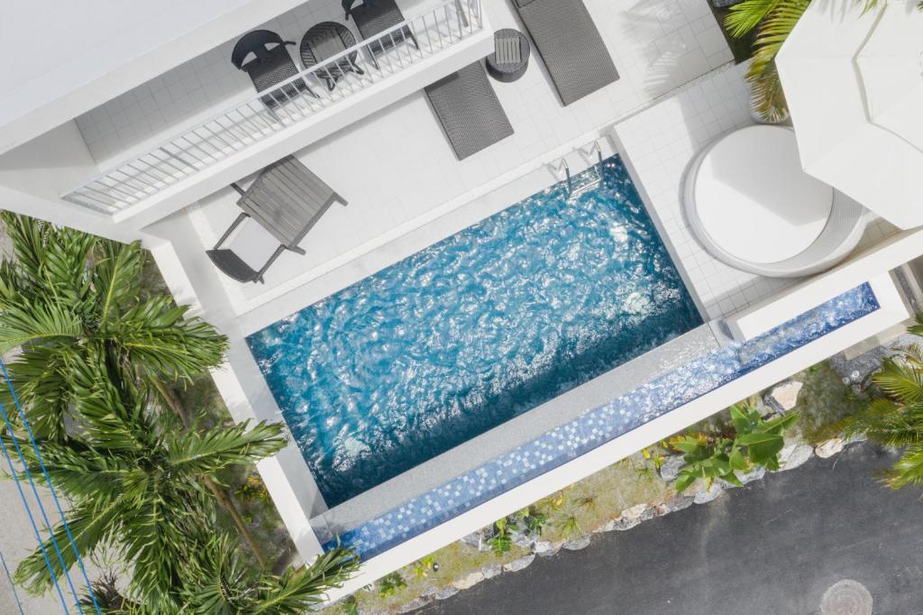 einen Blick über einen Pool in einem Haus mit Palmen in der Unterkunft KEN KEN VILLA YUUMODORO in Motobu