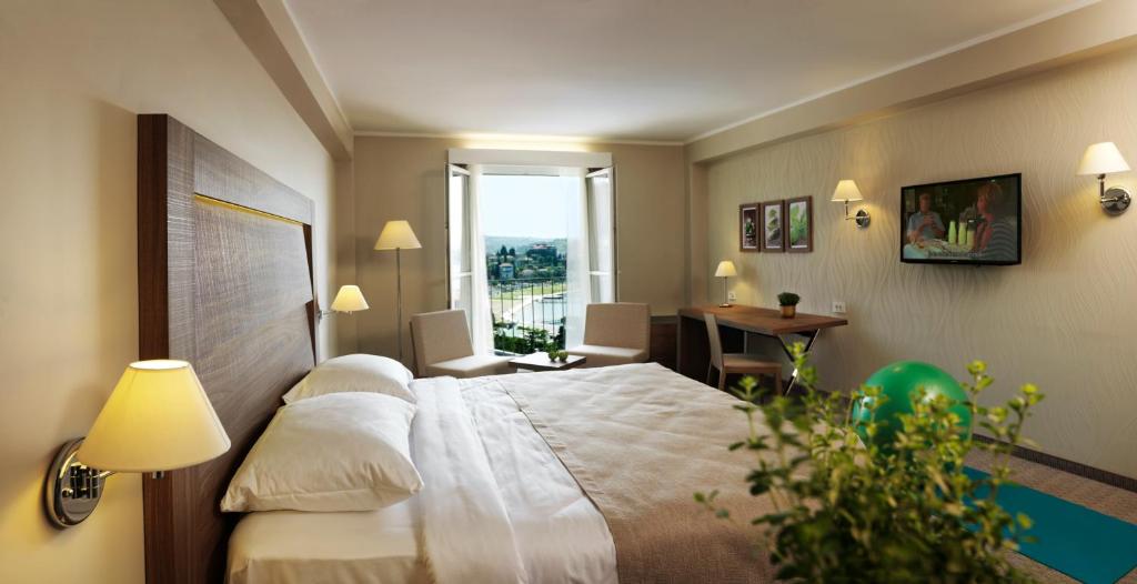 ein Hotelzimmer mit einem Bett und einem Fenster in der Unterkunft Wellness Hotel Apollo – Terme & Wellness LifeClass in Portorož