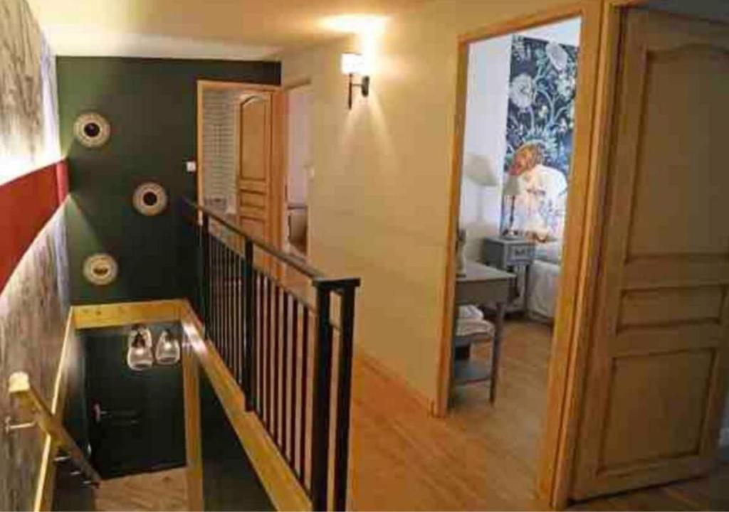 a hallway with a staircase and a room with a woman at Maison d'hôtes La Bella Casa in Villette-dʼAnthon