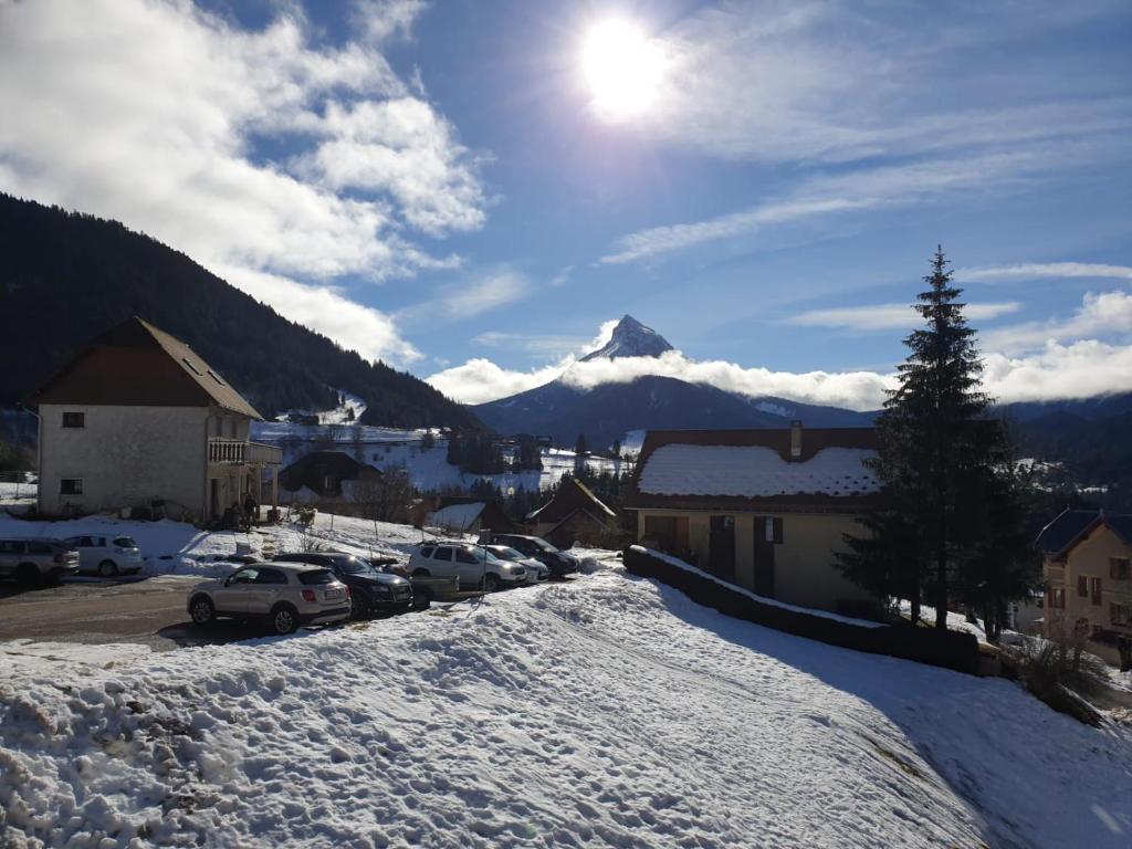 um parque de estacionamento coberto de neve com uma montanha ao fundo em Le Bois Joli em Saint-Pierre-de-Chartreuse