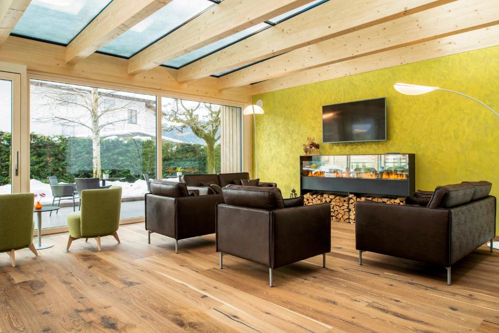 - un salon avec des fauteuils en cuir et une cheminée dans l'établissement Residence Hotel Eden - Family & Wellness Resort, à Andalo