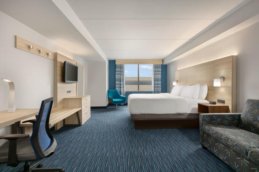 ノーフォークにあるHoliday Inn Express Hotel & Suites Norfolk Airport by IHGのベッドとソファのあるホテルの部屋