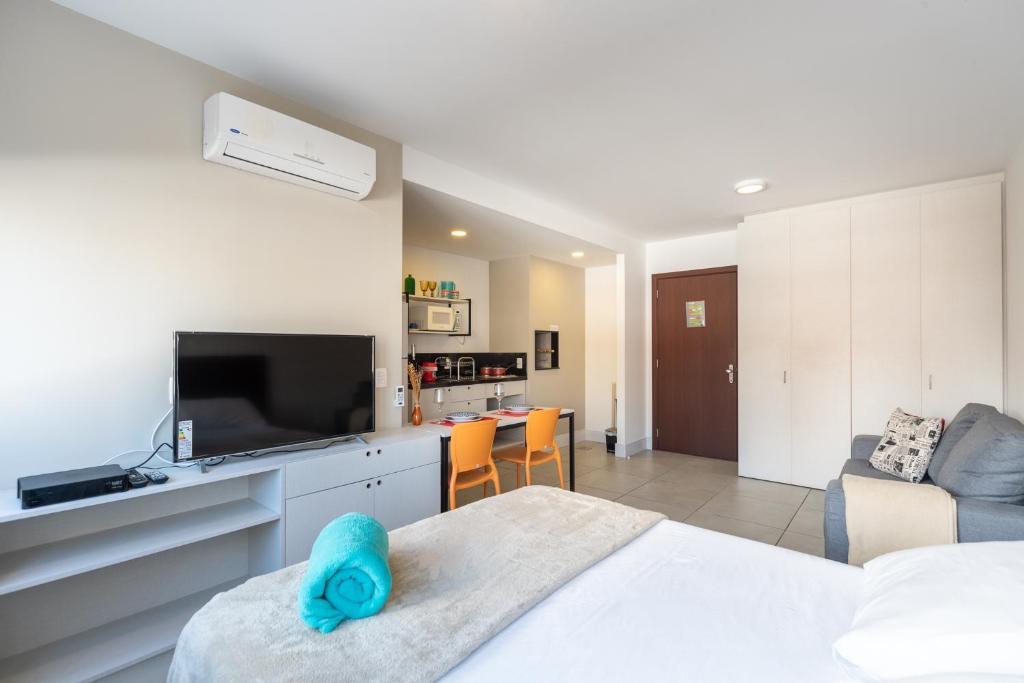 1 dormitorio con 1 cama y TV y sala de estar. en Apartamento incrível Pueblo 595, en Porto Alegre