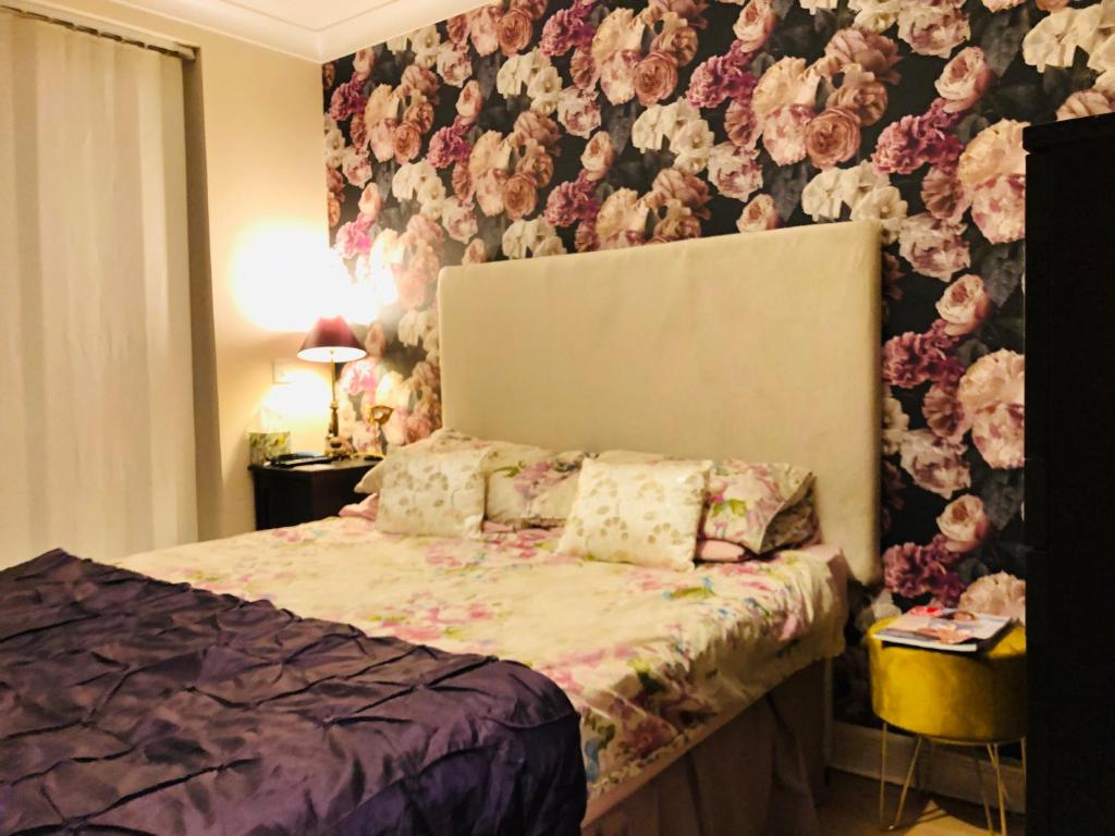 1 dormitorio con 1 cama y papel pintado con motivos florales en Beautiful apartment in SW London, en Sutton