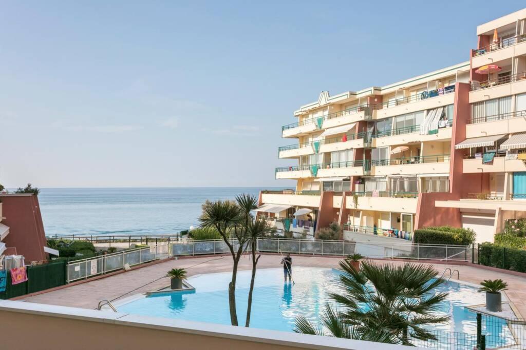 a view of a building with a swimming pool and the ocean at T3 climatisé avec piscine et vue sur mer in Sète