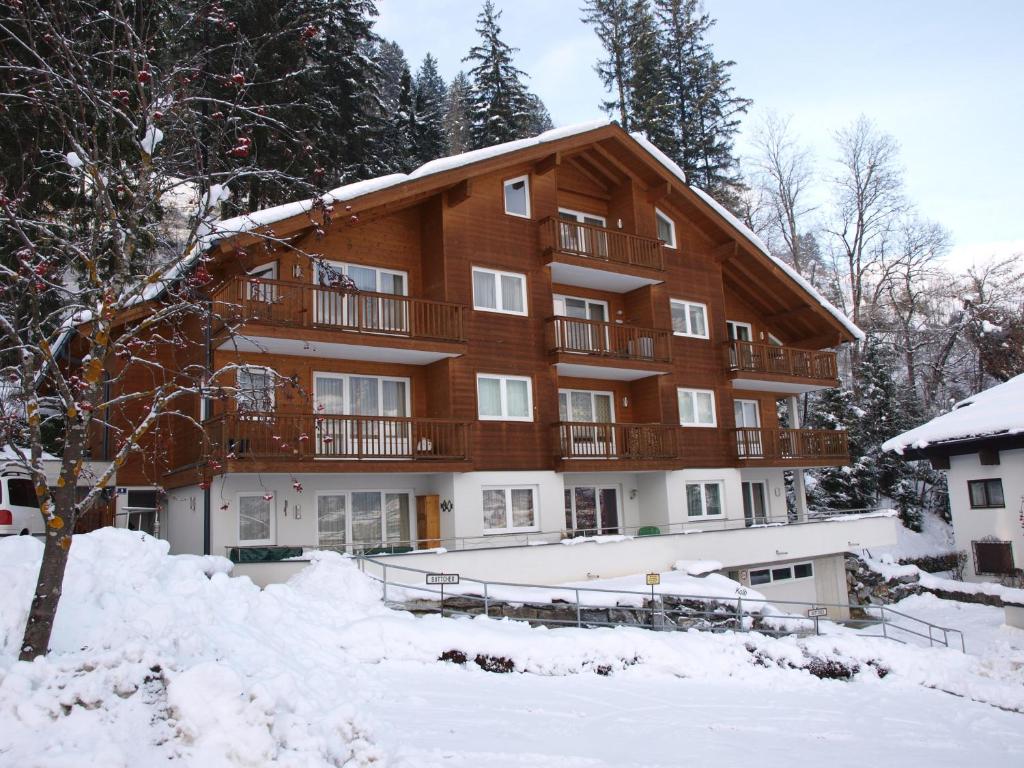 un gran edificio de apartamentos con nieve delante en Superior Appartement Schiwiese, en Bad Hofgastein