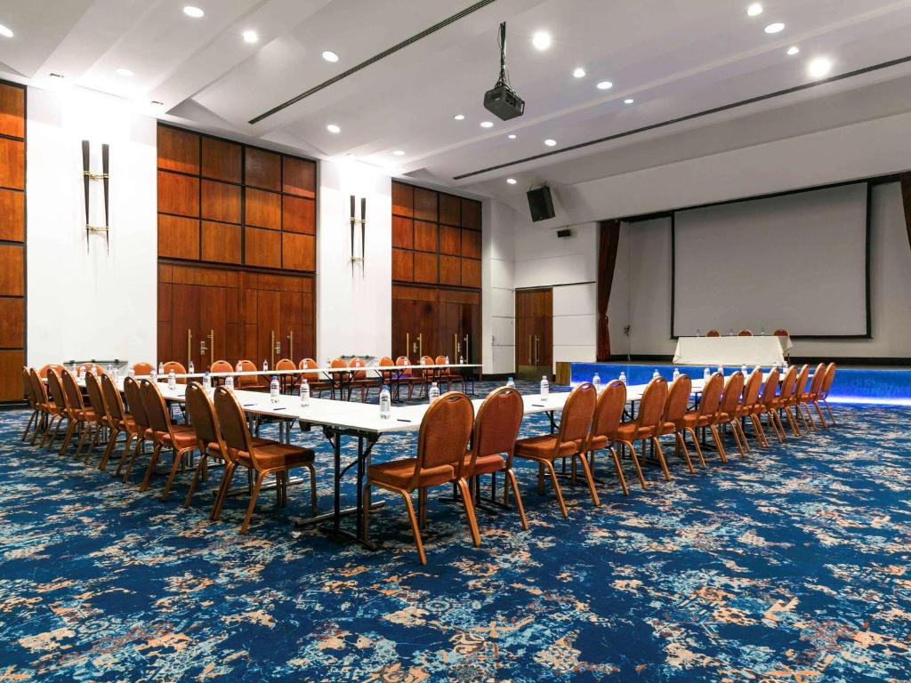 a conference room with a long table and chairs at Pullman Bucharest World Trade Center in Bucharest