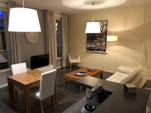 a living room with a table and a dining room at Meublé d'affaires place Dupleix in Châtellerault