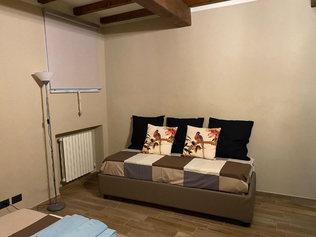 a bedroom with a bed with pillows and a lamp at Appartamento Frida in Parma