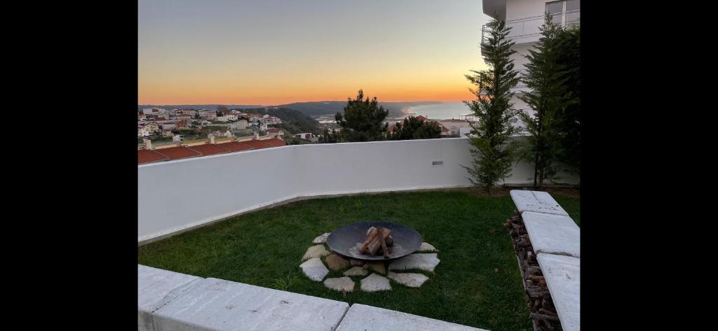 a backyard with a fire pit in the grass at Feel Nazaré - Ocean Villa in Nazaré