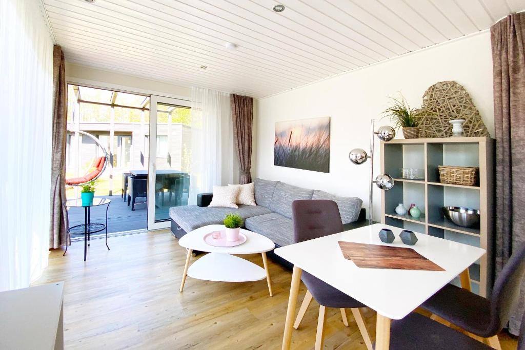 ein Wohnzimmer mit einem Sofa und einem Tisch in der Unterkunft Gronenberger Mühle Haus 1 in Scharbeutz