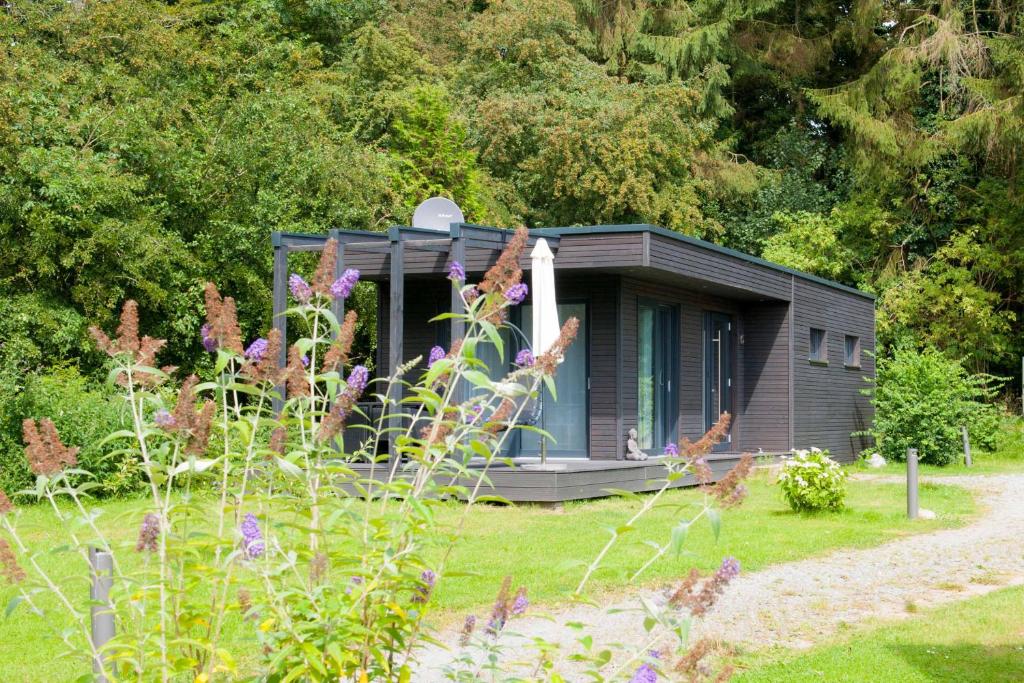 a small cabin in the middle of a garden at Gronenberger Mühle Haus 6 in Scharbeutz