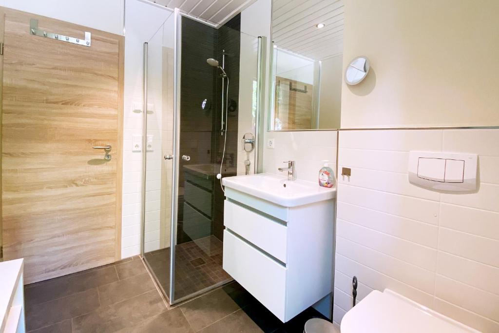 y baño con lavabo blanco y ducha. en Gronenberger Mühle Haus 10, en Scharbeutz