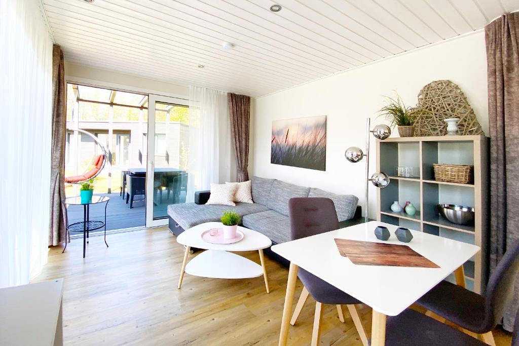 ein Wohnzimmer mit einem Sofa und einem Tisch in der Unterkunft Gronenberger Mühle Haus 16 in Scharbeutz
