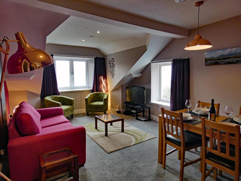 a living room with a red couch and a table at Bryn Melyn Apartments in Barmouth