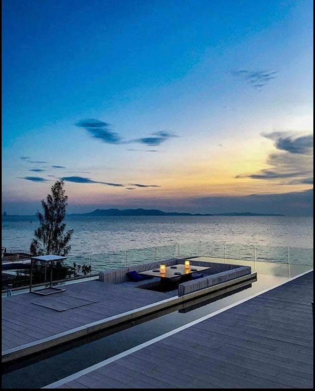a patio with a table and a view of the water at Veranda Residence Pattaya by One in Na Jomtien