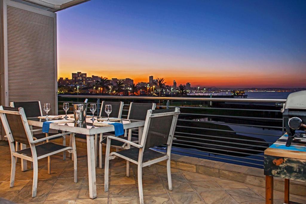 a table and chairs on a balcony with a view of the city at Durban Point Waterfront, 304 The Quays in Durban